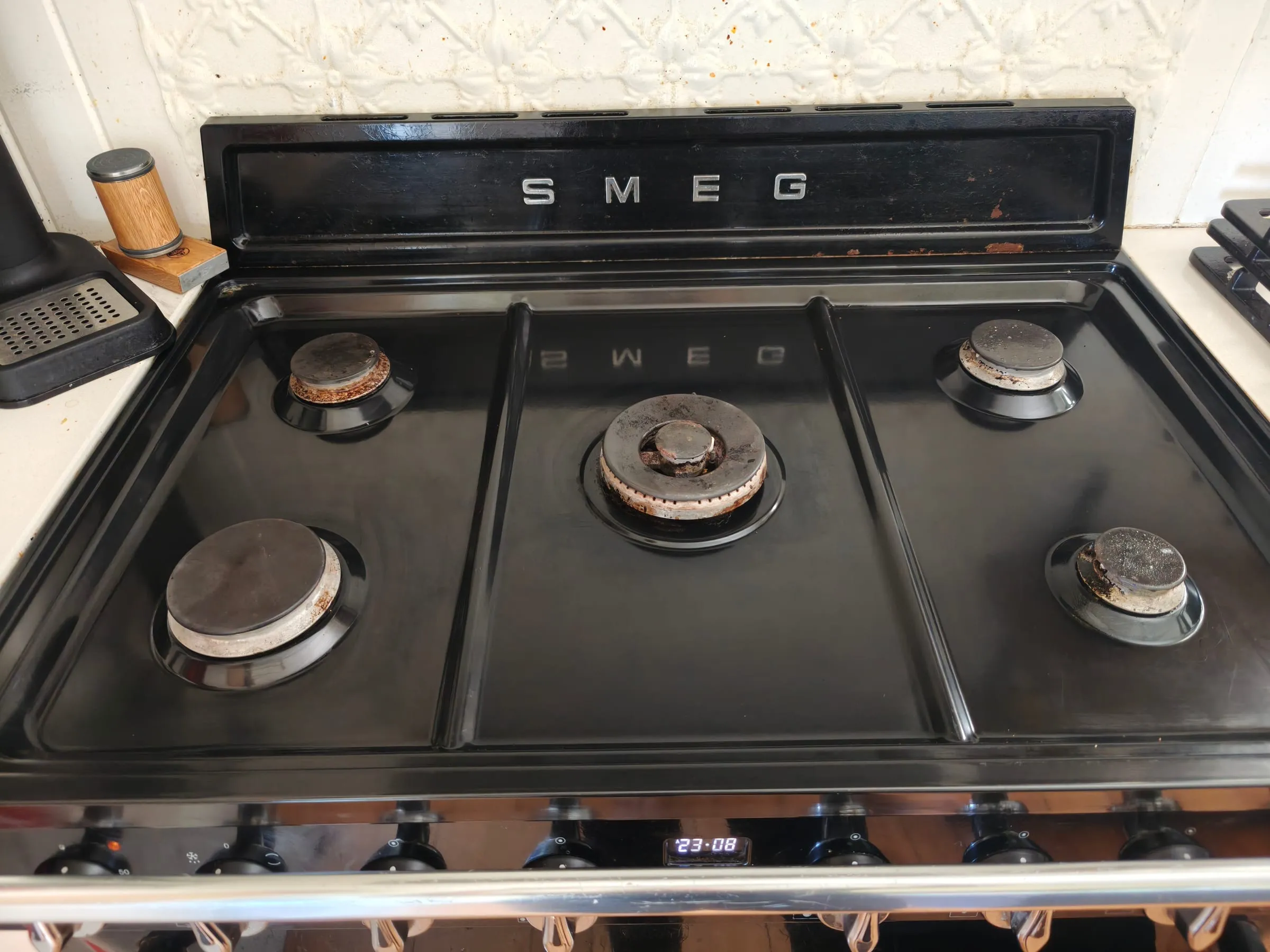 The same gas cooktop after the deep clean, the enamel wiped back to an even black finish