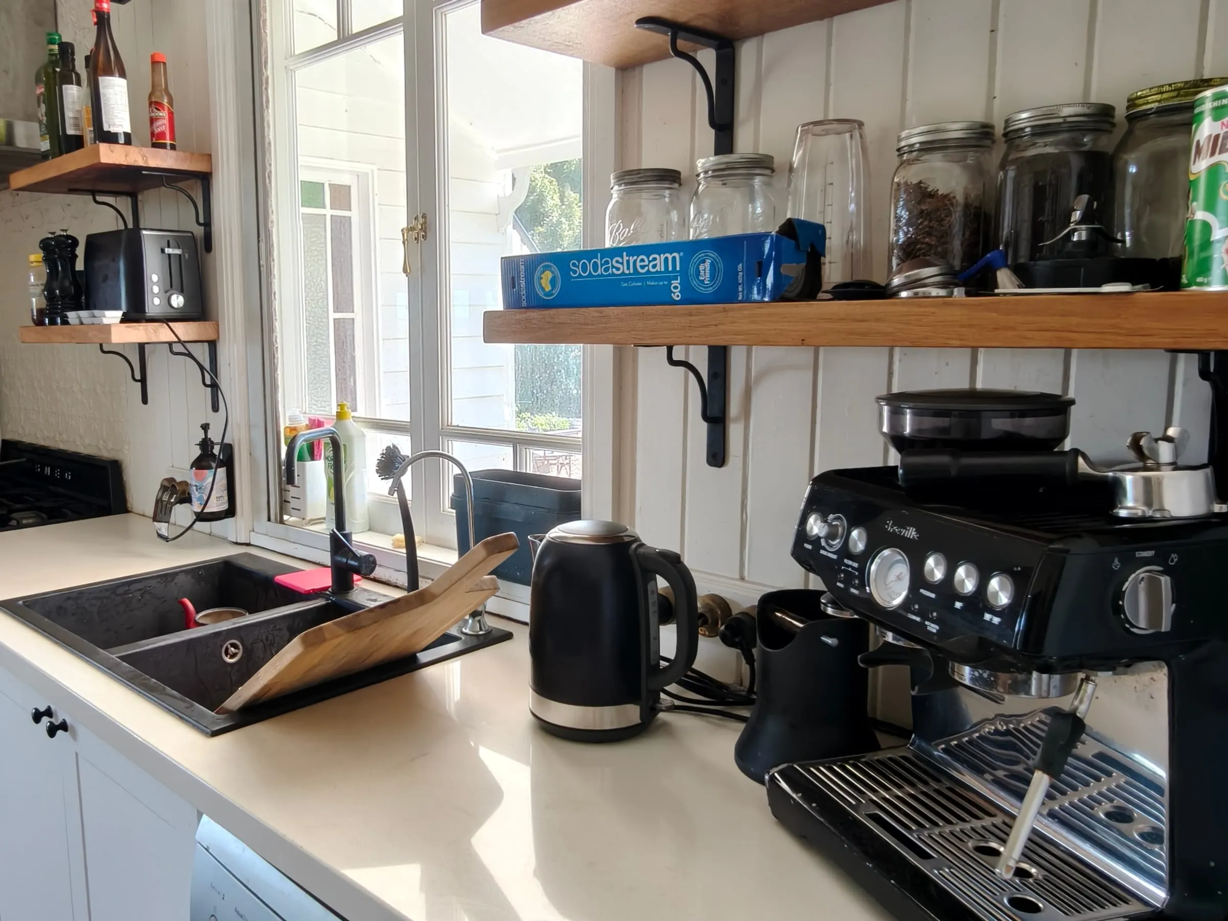 The same kitchen benchtop after the deep clean, sink empty and the bench clear and wiped down