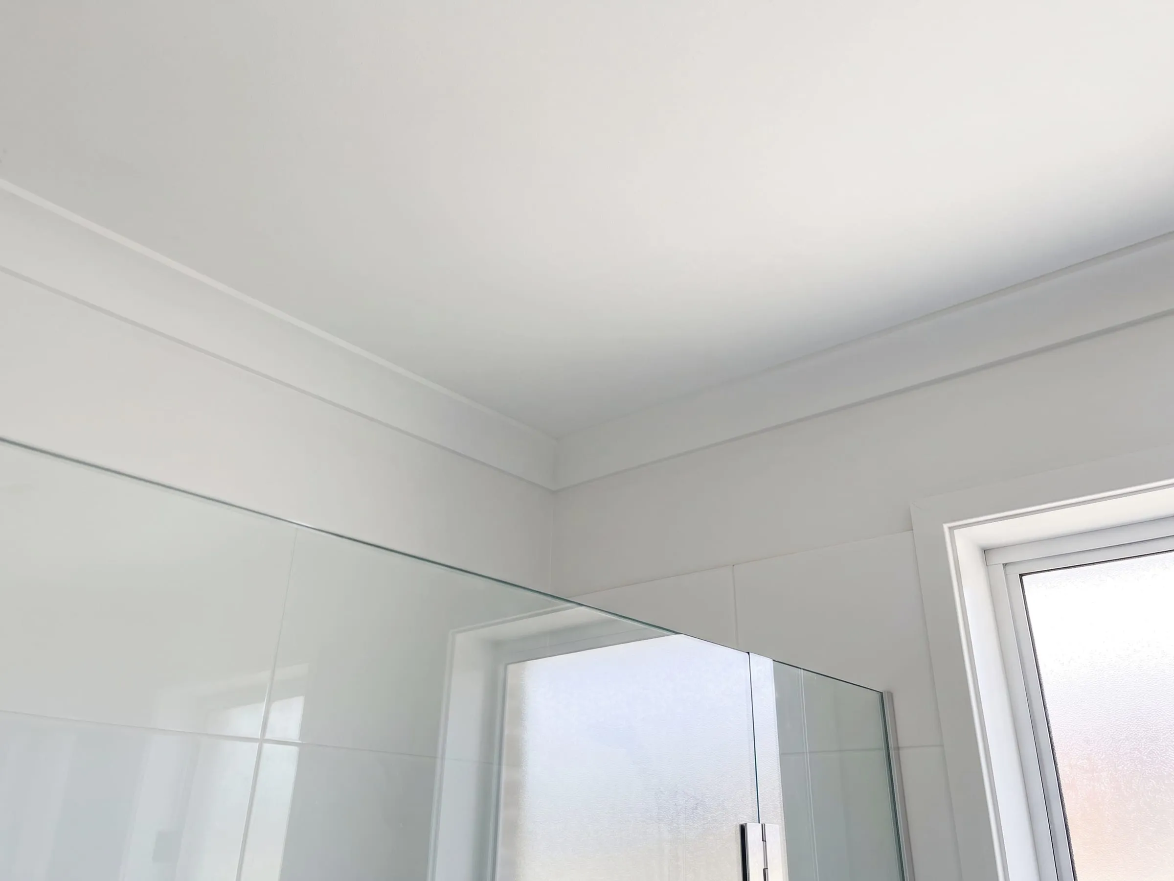 Illustration: the same bathroom ceiling and cornice after treatment, the spotting gone and the paint back to an even white