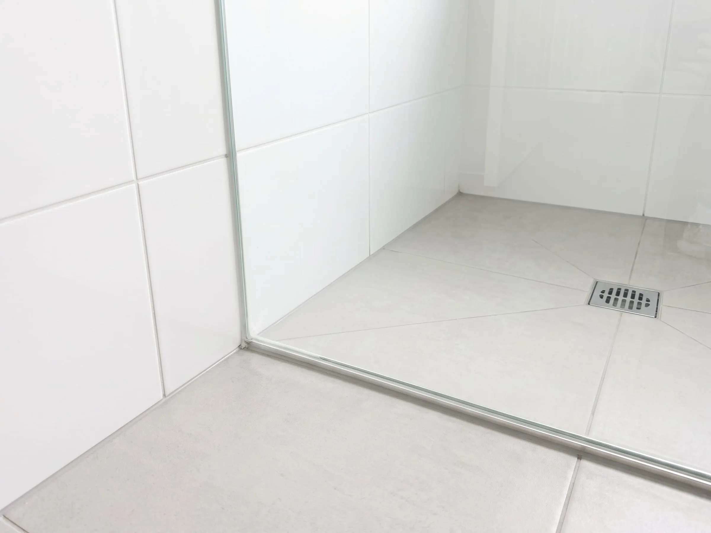 Illustration: the same shower corner after treatment, the grout and seal clean and the glass clear